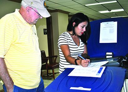 Scurry County Deputy County Clerk Selene Gallegos (right) showed Barney Tate a sample ballot at the public test of the voting machines Thursday. Early voting for the Nov. 8 general election will begin Monday on the first floor of the Scurry County Courthouse.