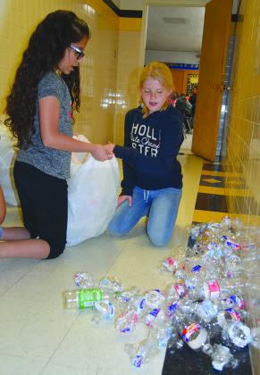 Fifth graders Zoey Ramon (left) and Madilyn King bagged water bottles.