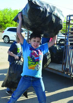 Fourth grader Conner Reese unloaded a bag of water bottles from a trailer.