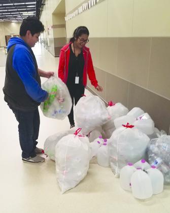 Snyder Junior High School students Carlos Chavez (left) and Tiffany Salinas piled bags of water bottles in the hallway.