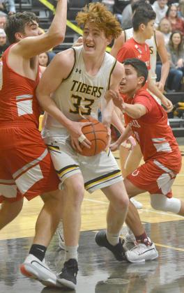 Snyder junior Zach Miller (center) battled his way through a pair of Sweetwater defenders on his way to a layup during the Tigers’ 72-32 win over the Mustangs Friday.